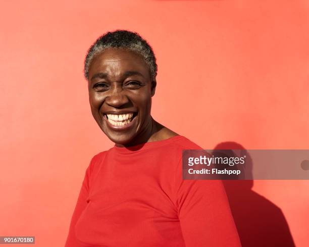 portrait of mature woman laughing - woman studio shot stock pictures, royalty-free photos & images