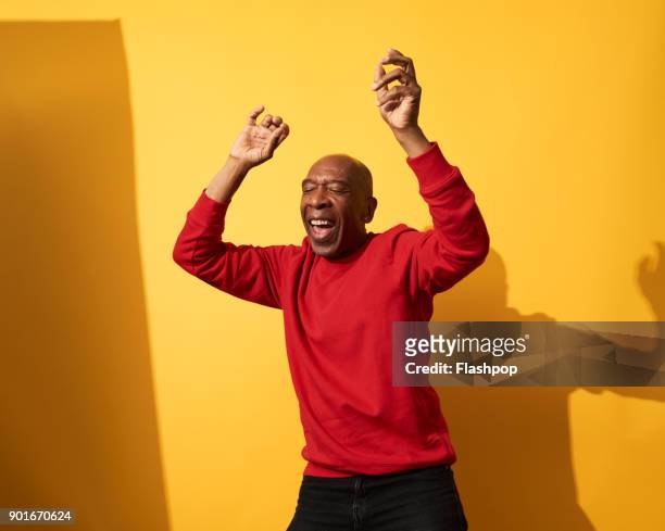 portrait of mature man dancing and having fun - braccia alzate foto e immagini stock