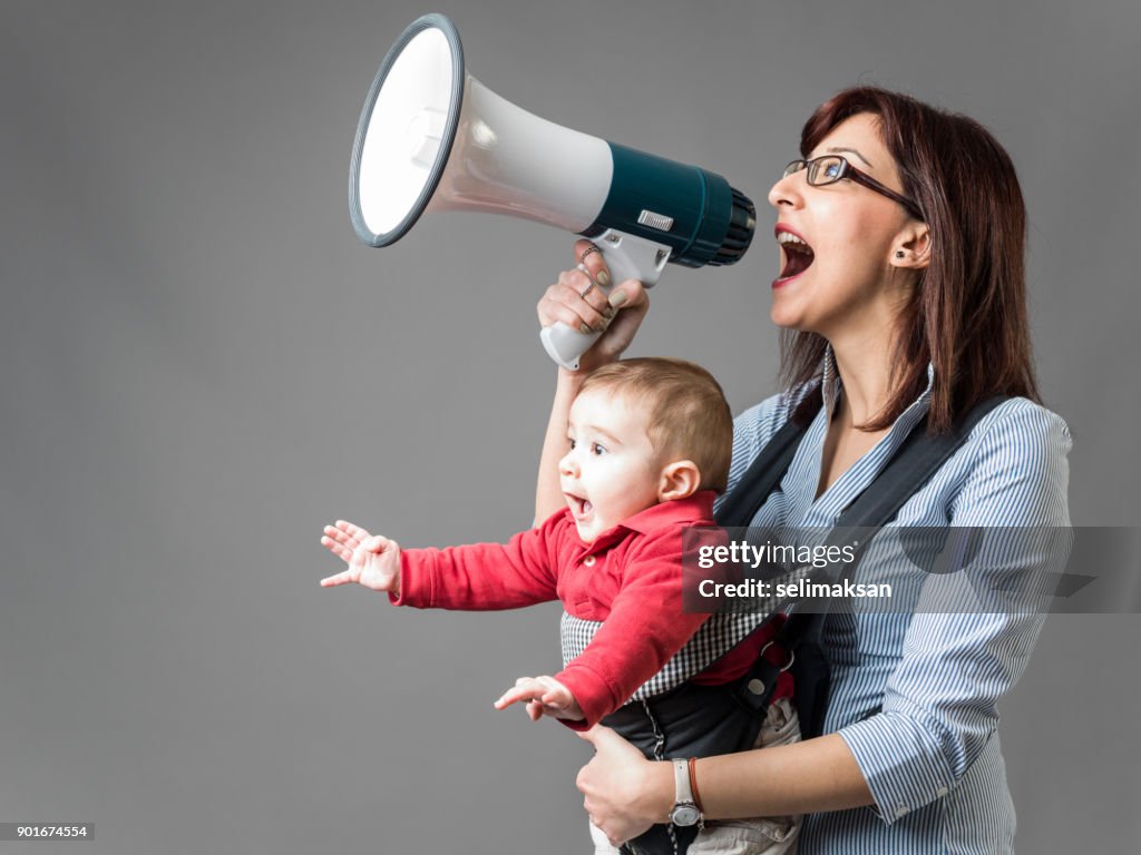 Mother Carrying Her Baby And Shouting Through Megaphone