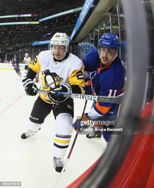 Matt Hunwick of the Pittsburgh Penguins and Shane Prince of the New York Islanders pursue the puck during the second period at the Barclays Center on...