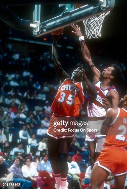 Phil Hubbard of the Cleveland Cavaliers shoots over Cliff Robinson of the Washington Bullets during an NBA basketball game circa 1985 at the Capital...