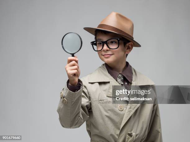 little boy looking through magnifying glass - sherlock holmes stock pictures, royalty-free photos & images