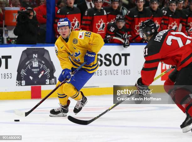 Alexander Nylander of Sweden skates up ice with the puck as Brett Howden of Canada defends in the second period during the Gold medal game of the...