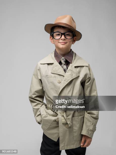 well dressed little boy wearing trench coat and glasses - trench coat stock pictures, royalty-free photos & images