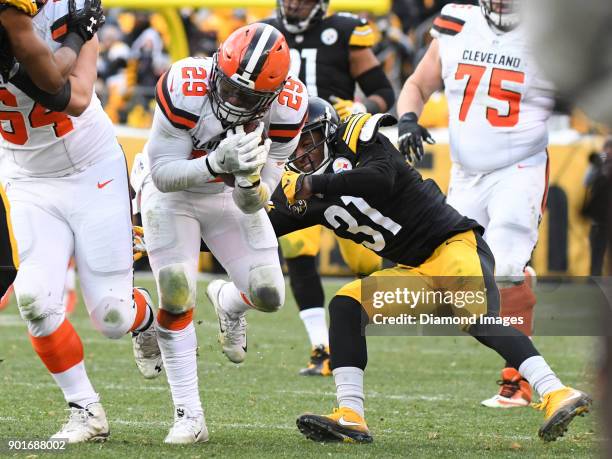Running back Duke Johnson Jr. #29 of the Cleveland Browns breaks the tackle of cornerback Mike Hilton of the Pittsburgh Steelers in the fourth...