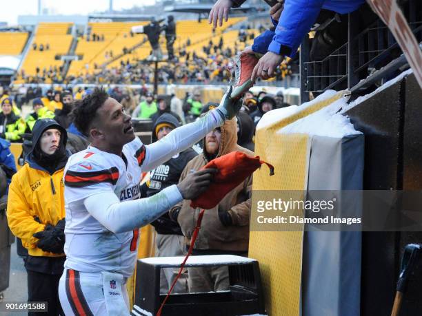 Quarterback DeShone Kizer of the Cleveland Browns hands parts of his equipment to fans after a game on December 31, 2017 against the Pittsburgh...