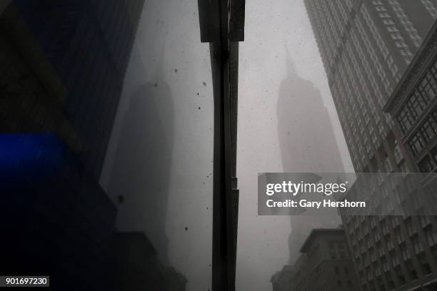 The Empire State Building is reflected in a window during a winter storm called a "bomb cyclone" on January 4, 2018 in New York City.