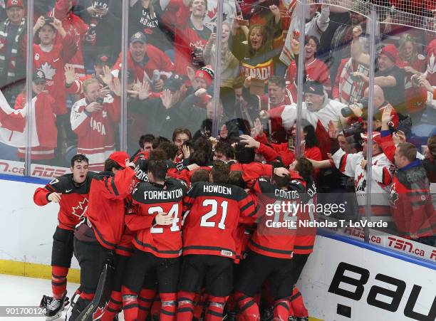 Players from team Canada celebrate their 3-1 win over Sweden following the final horn of the third period in the IIHF World Junior Championships Gold...