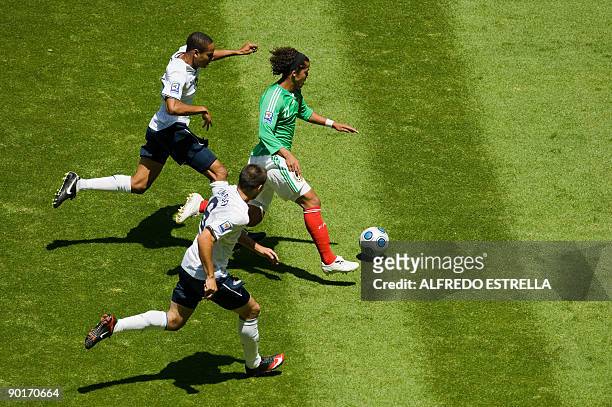 Mexico's Giovani Dos Santos vies for the ball with US players Ricardo Clarck and Clinton Dempsey , during their football qualifier at Azteca stadium...