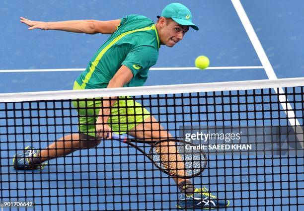 Alex De Minaur of Australia hits a return against Ryan Harrison of the US during their men's singles semi-final match at the Brisbane International...