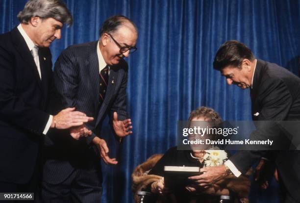 President Ronald Reagan awards Singer Kate Smith the Medal of Freedom for her performance of "God Bless America", accompanied by Senator Jesse Helms...