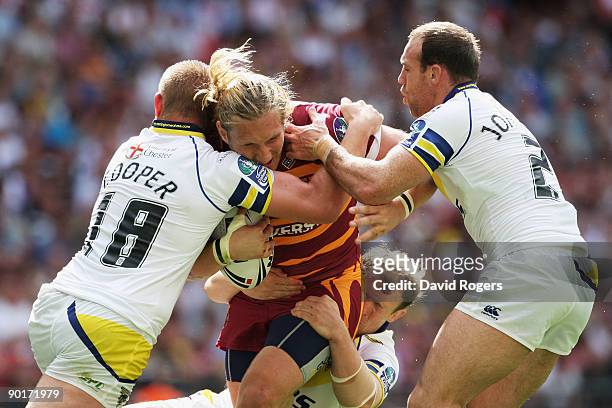 Eorl Crabtree of Huddersfield is halted by Michael Cooper , Mick Higham and Paul Johnson of Warrington defence during the Carnegie Challenge Cup...
