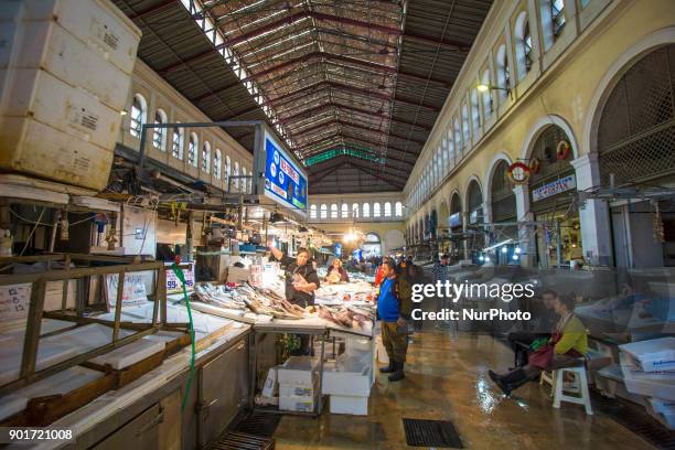 Varvakios Agora or the Central Fish Market in Athens, Greece. Seafood Stalls with fishmongers and shoppers buying fresh seafood that was catched a...