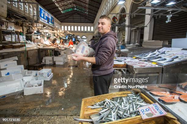 Varvakios Agora or the Central Fish Market in Athens, Greece. Seafood Stalls with fishmongers and shoppers buying fresh seafood that was catched a...