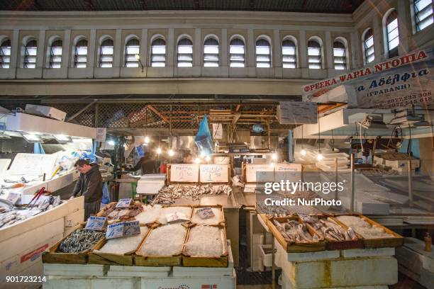 Varvakios Agora or the Central Fish Market in Athens, Greece. Seafood Stalls with fishmongers and shoppers buying fresh seafood that was catched a...