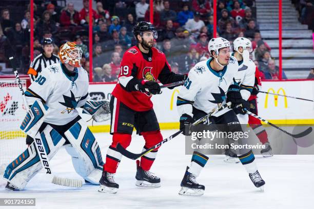 Ottawa Senators Center Derick Brassard battles San Jose Sharks Defenceman Justin Braun for space in front of San Jose Sharks Goalie Aaron Dell during...