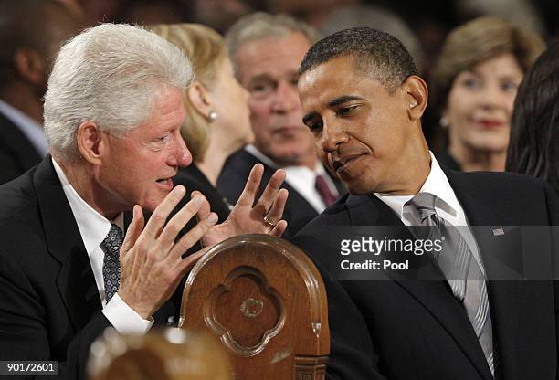 Former President Bill Clinton talks with President Barack Obama as Secretary of State Hillary Clinton talks with former President George W. Bush as...