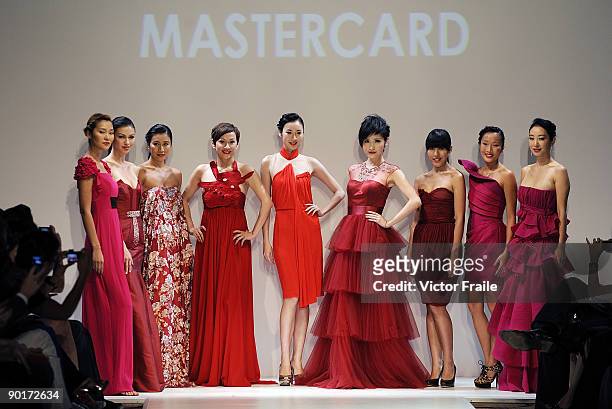 Models showcase designs on the catwalk at the end of the Red Dress Collection showcase during the Mastercard Luxury Week Hong Kong 2009 at The Four...
