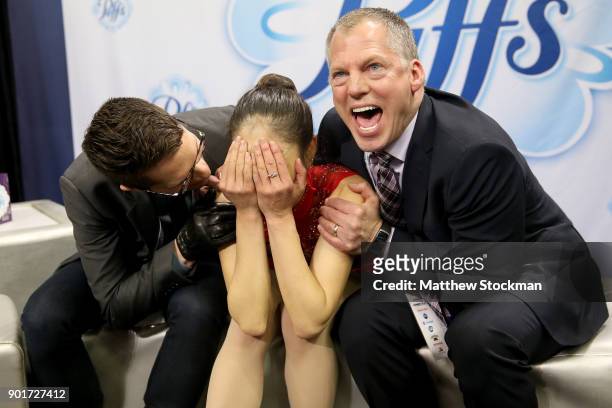 Mirai Nagasu celebrates in the kiss and cry with coaches Drew Meekins and Tom Zakrajsek after skating in the Ladies Free Skate during the 2018...
