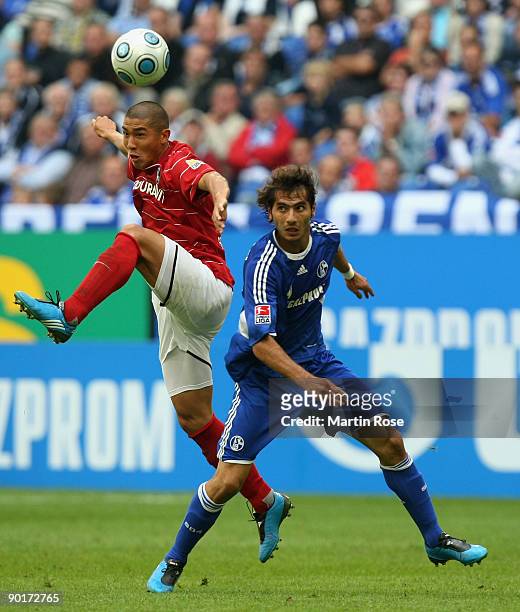 Halil Altintop of Schalke and Du RI Cha of Freiburg jump for a header during the Bundesliga match between FC Schalke 04 and SC Freiburg at the...