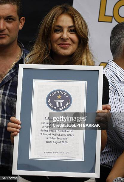 Lebanese Rima Franjiyeh, director of Al-Maidan NGO, poses with a Guiness World Records certificate after volunteers from the organisation created the...