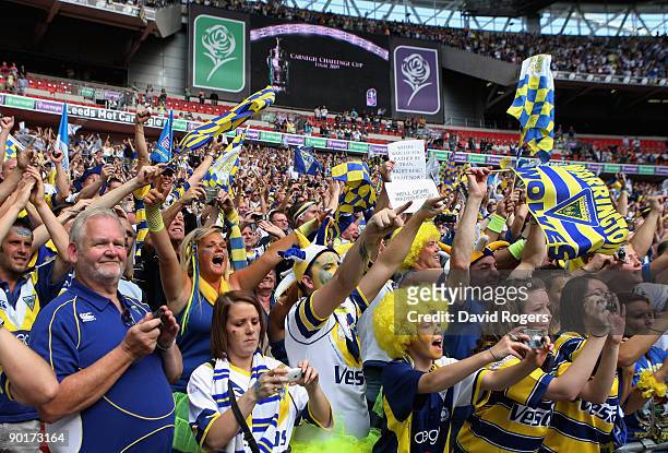 Warrington fans celebrate following their teams victory during the Carnegie Challenge Cup Final between Huddersfield Giants and Warrington Wolves at...