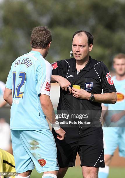 Referee Rob Shoebridge shows a yellow card to Ryan Gilligan of Northamppotn during the Coca Cola League Two Match between Burton Albion and...