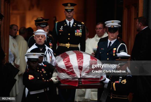Military honor guard carries the rain-protected coffin of Senator Edward Kennedy outside of the Basilica of Our Lady of Perpetual Help after the...
