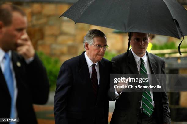 Steady rain pours down as Senate Minority Leader Mitch McConnell leaves the funeral service for Sen. Edward Kennedy at Our Lady of Perpetual Help...