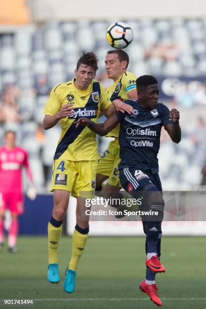 Alan Baro of the Central Coast Mariners , Jake McGing of the Central Coast Mariners and Leroy George of Melbourne Victory all contest the ball during...