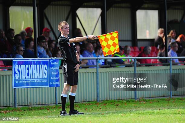 Young linesman Daniel Mawer flags for offside during the FA Cup Preliminary Round match between Poole Town and Barnstaple Town at Tatnum Ground on...