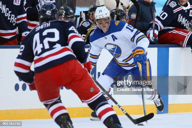 Jack Eichel of the Buffalo Sabres skates with the puck against Brendan Smith of the New York Rangers during the 2018 Bridgestone NHL Winter Classic...