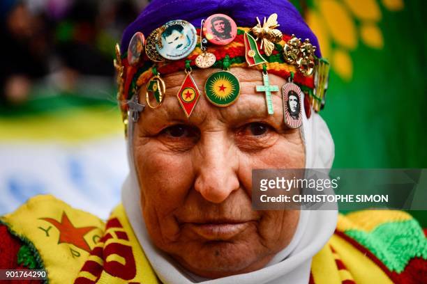 Kurdish woman wearing Kurdish badges on her head, takes part in a demonstration in Paris on January 6 in tribute to the three Kurdish female...