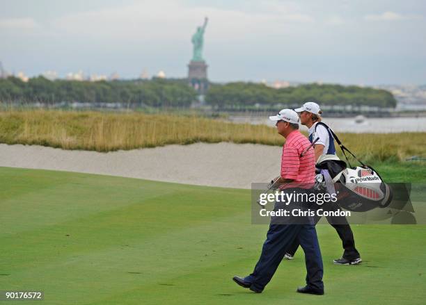 Paul Goydos and his caddie walk up the 18th fairway during the third round of The Barclays at Liberty National Golf Club on August 29, 2009 in Jersey...