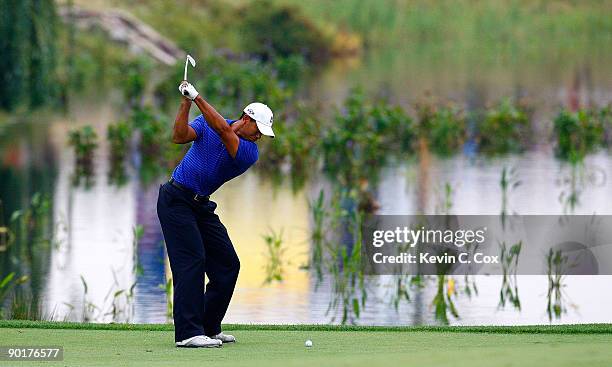 Tiger Woods plays his fourth shot in the 13th fairway after a drop during round three of The Barclays on August 29, 2009 at Liberty National in...