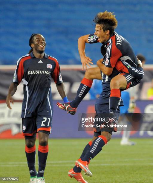 Shalrie Joseph looks on as Wells Thompson of the New England Revolution jumps into the arms of teammate Kheli Dube as he celebrates his goal against...