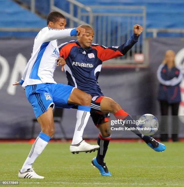 Darrius Barnes of the New England Revolution kicks the ball away from Ryan Johnson of the San Jose Earthquakes during MLS match August 29 at Gillette...