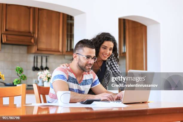 couple using laptop at home - examining stock pictures, royalty-free photos & images