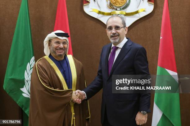 Jordanian Foreign Minister Ayman Safadi shakes hands with UAE Minister of State for Foreign Affairs Anwar Gargash during a meeting in the Jordanian...