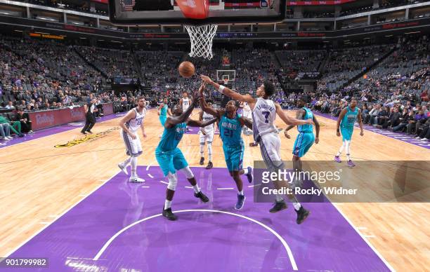 Skal Labissiere of the Sacramento Kings rebounds against Johnny O'Bryant III and Treveon Graham of the Charlotte Hornets on January 2, 2018 at Golden...
