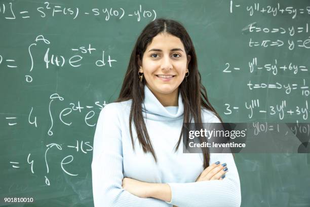 studentin, die mathematische formel vor der tafel schreiben - mathematische funktion stock-fotos und bilder