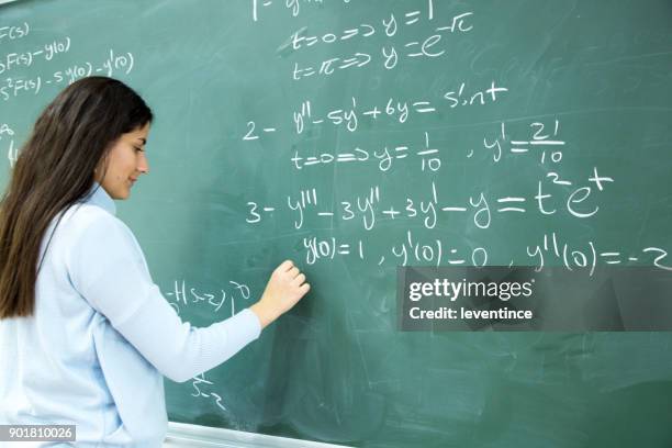studentin, die mathematische formel vor der tafel schreiben - mathematische funktion stock-fotos und bilder
