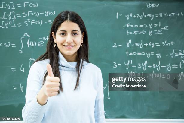 studentin, die mathematische formel vor der tafel schreiben - mathematische funktion stock-fotos und bilder