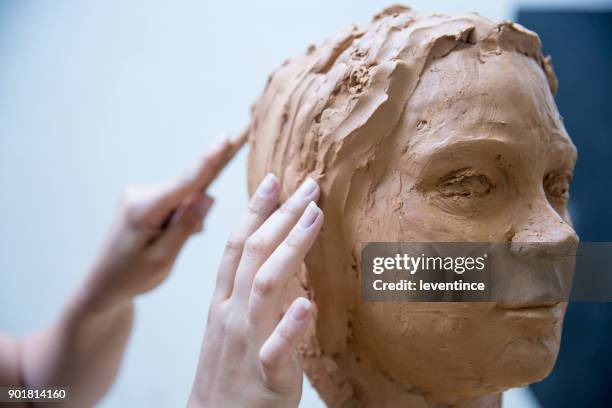 artist working on clay sculpture in art studio - escultura imagens e fotografias de stock