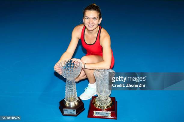 Simona Halep of Romania poses for photo with her Single's and Double's Champion trophies during Day 7 of 2018 WTA Shenzhen Open at Longgang...