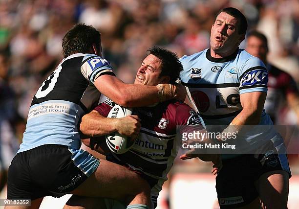 Chris Bailey of the Sea Eagles is tackled high by Luke Douglas of the Sharks which leads to his sending off during the round 25 NRL match between the...