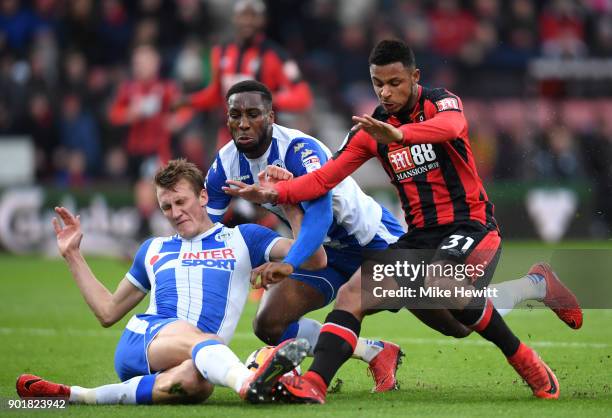 Dan Burn and Cheyenne Dunkley of Wigan Athletic challenge Lys Mousset of AFC Bournemouth during the The Emirates FA Cup Third Round match between AFC...