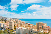 Panoramic aerial top view to Fuengirola town and its surroundings, hotels, resorts, buildings and beaches of Mediterranean sea on sunny day, Andalusia, Spain. Winter relax vacation by the sea concept.