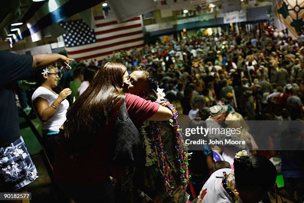 Family members embrace Sgt. Kalanikia Liana from Waianae, Hawaii after adorning him with leis after he and fellow U.S. Army soldiers returned home...