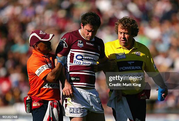 Chris Bailey of the Sea Eagles is taken from the field after being tackled high by Luke Douglas of the Sharks which lead to his sending off during...